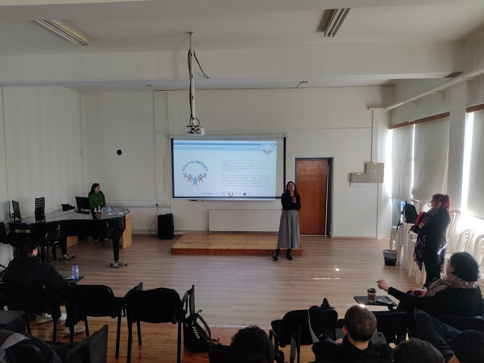 Speaker presenting a slide to attendees in a large hall.